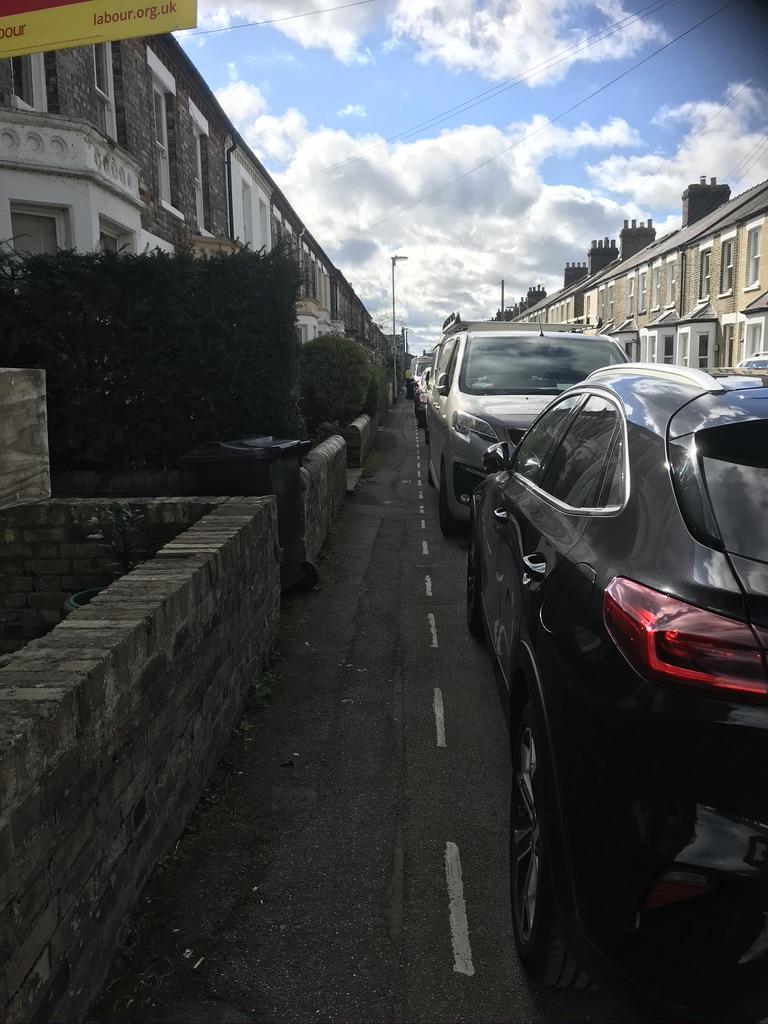 cars parked on pavement block entrances to homes