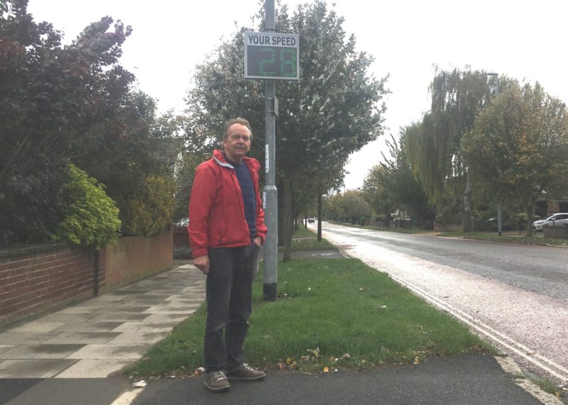 Councillor Mike Sargeant standing by a speed restriction sign