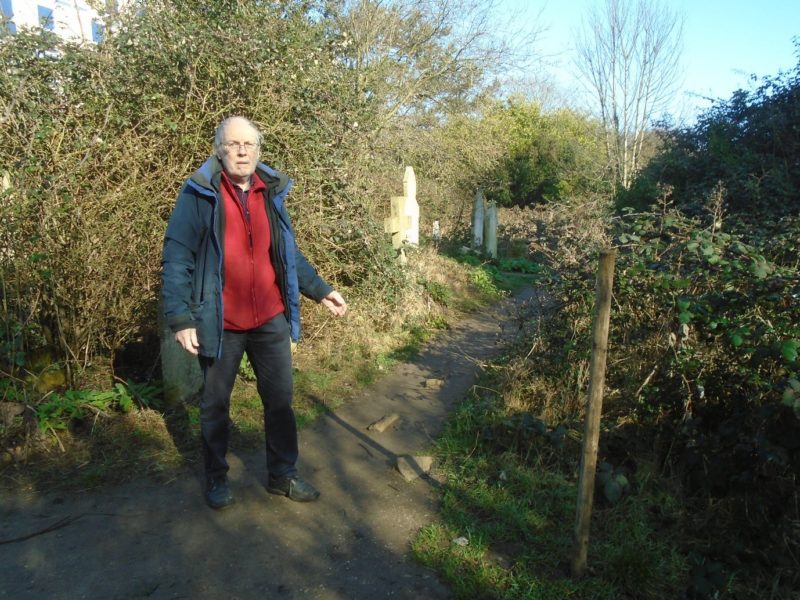 Councillor Richard Robertson points out the damage done to paths in the cemetery