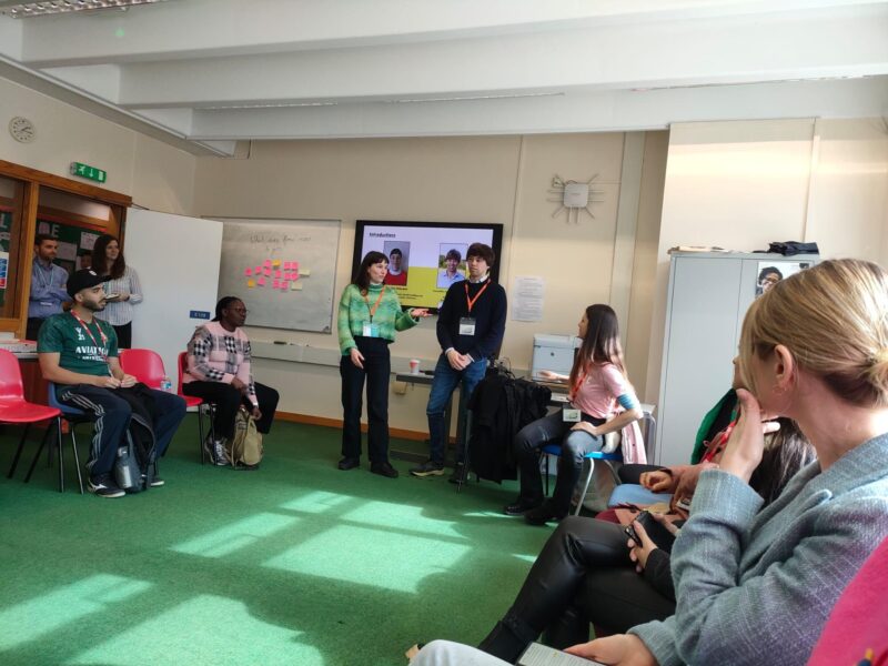 Photo of Cameron Holloway and Alice Gilderdale engaging with ESOL learners at Cambridge Regional College